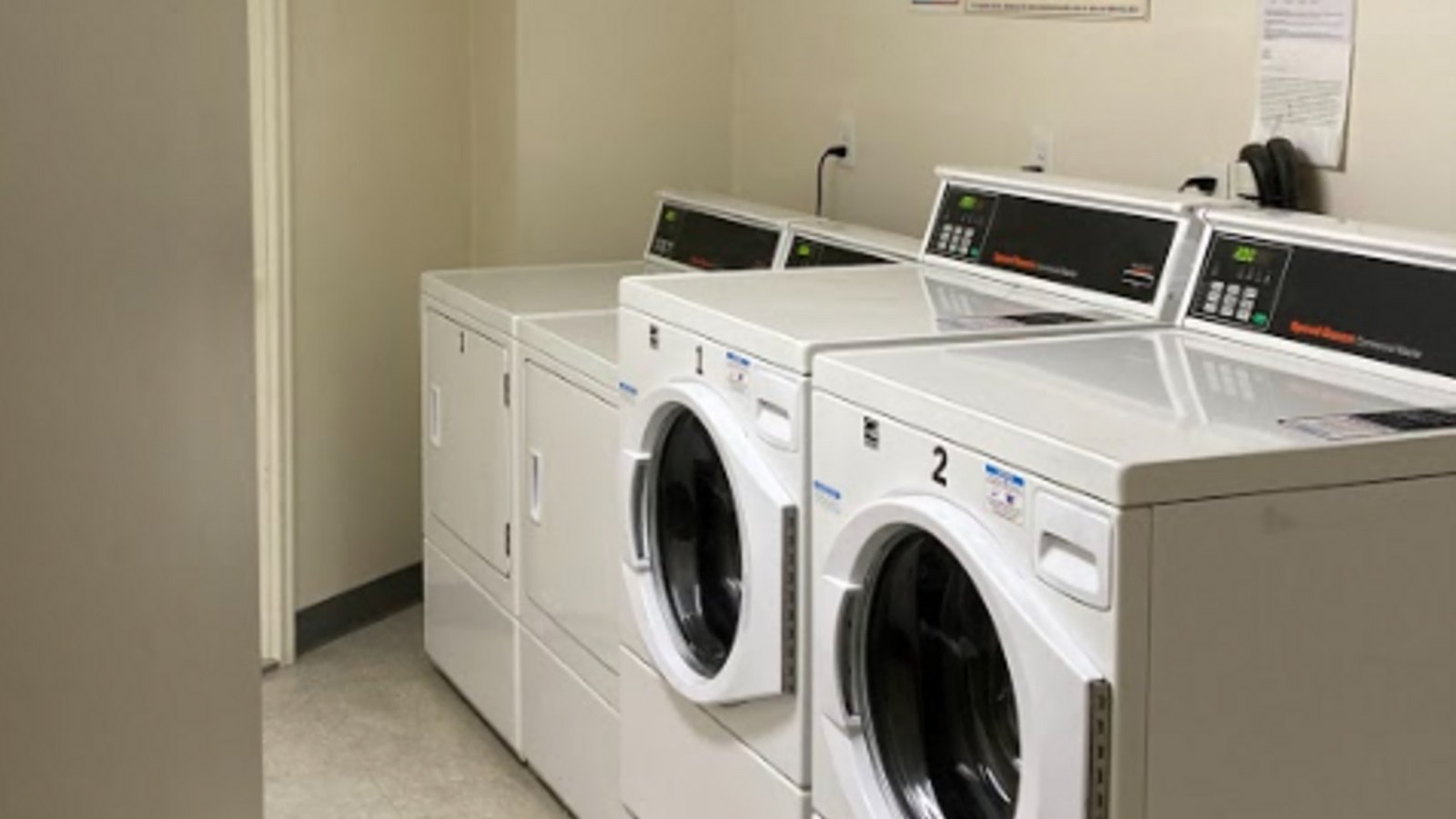 Residential laundry room with dryer setup and vent access